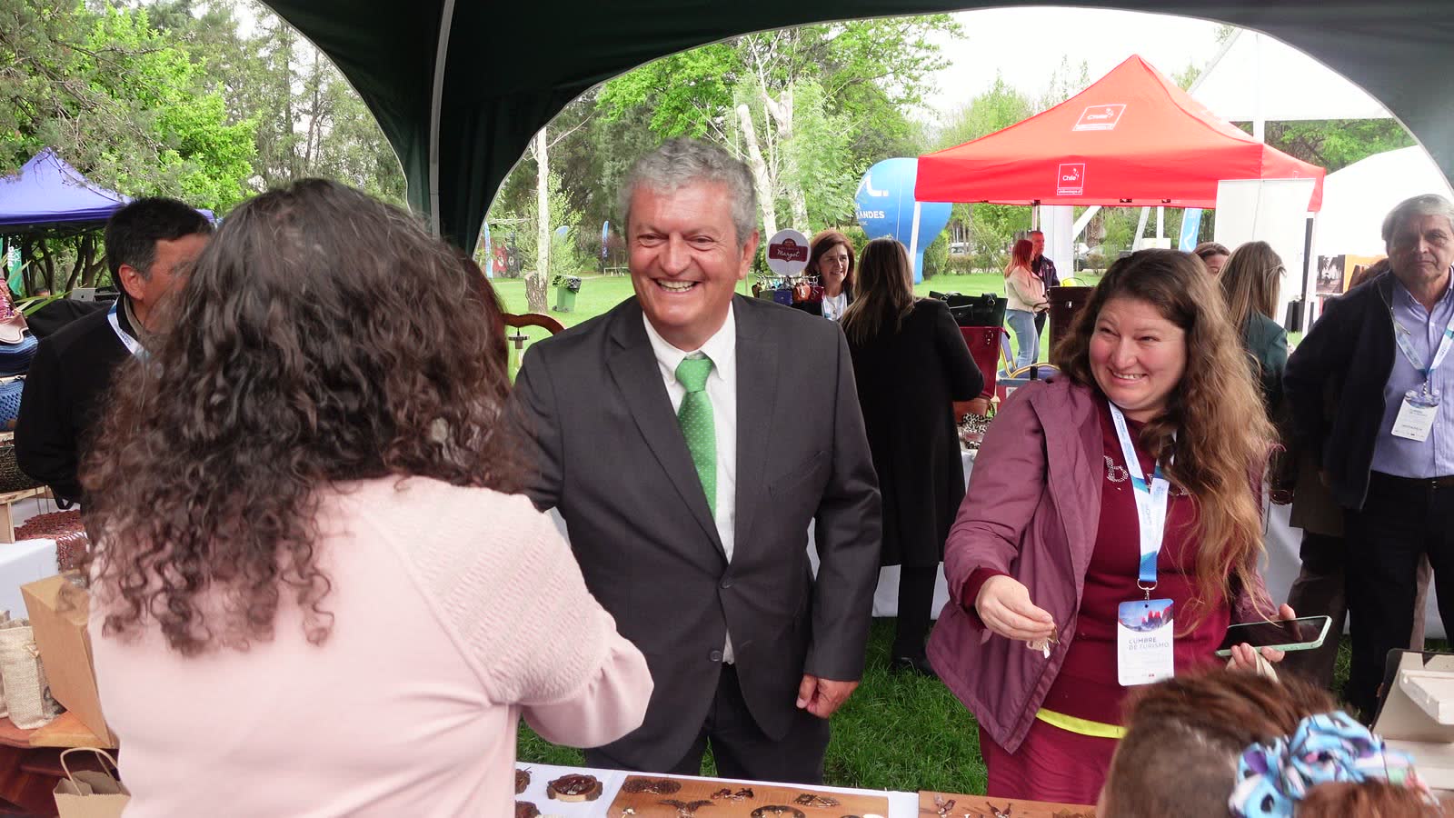 Alcalde Jaime Escudero con corbata verde saludando a emprendedoras pircanas